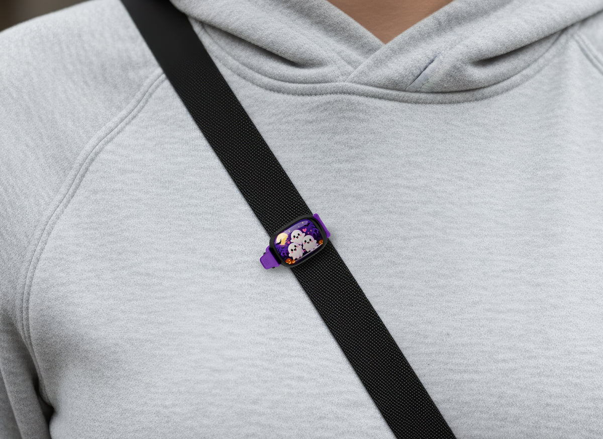 Three Cute Ghosts Stwrap bag tag on a diagonal black strap over a gray sweatshirt