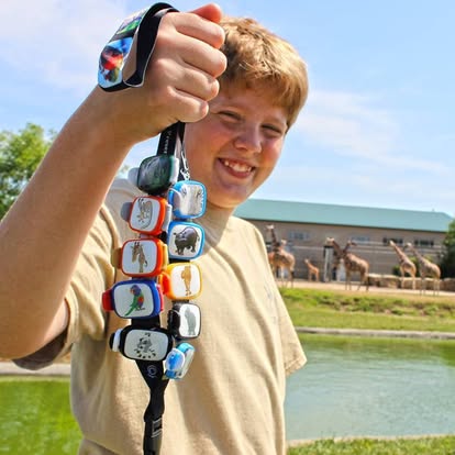 Young Tanganyika Wildlife Park guest holding a lanyard filled with collectible animal Stwraps